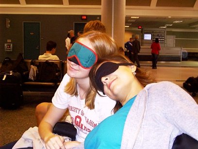 Stephanie and Julianna wearing sleep masks and feigning unconsciousness in Atlanta Airport (Photo Courtesy of Julianna Parker)