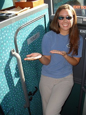 Katie does a Vanna impression and shows off the bus's WC