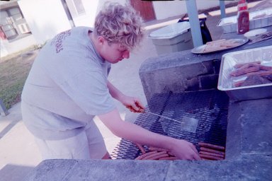 Gourmet Chef Chuck Hodges works with some burgers and all of the hot dogs on the lower-heat side.